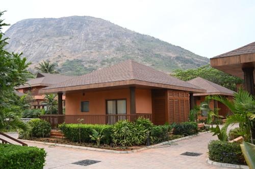 ein Haus mit einem Berg im Hintergrund in der Unterkunft Mulberry Shades Bengaluru Nandi Hills - a Tribute Portfolio Resort in Bangalore