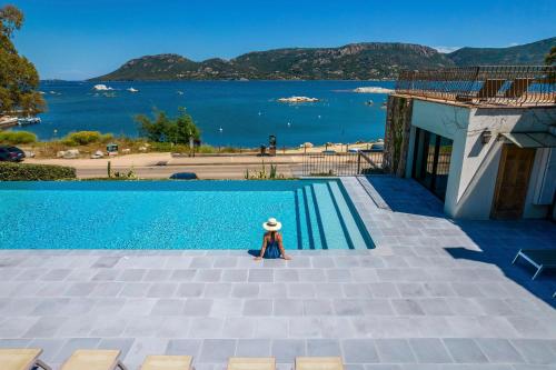 una statuina di una persona seduta accanto alla piscina di Hotel Shegara a Porto Vecchio