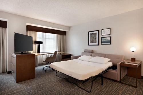 a hotel room with a bed and a flat screen tv at Residence Inn by Marriott Baltimore Downtown/ Inner Harbor in Baltimore