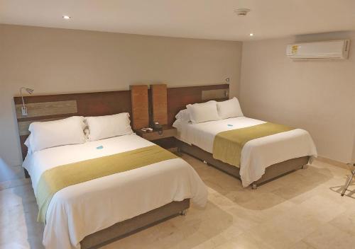 a hotel room with two beds in a room at Washington Plaza in Barranquilla