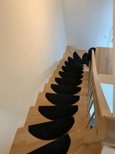 eine Treppe mit schwarzen Wendeltreppen in einem Zimmer in der Unterkunft 2 Zimmer im Loft style über 2 Etagen in Kelheim