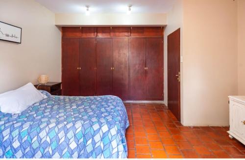 a bedroom with a bed and a wooden closet at Casa Salta in Salta