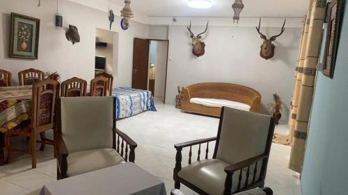 a room with a bed and chairs and antlers on the wall at Justice Seaview Apartment in Le Morne