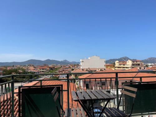 balcón con mesa y vistas a la ciudad en La Cupola 129, en Olbia