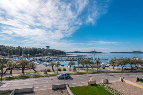 Blick auf den Yachthafen mit einem Auto, das eine Straße hinunterfährt in der Unterkunft Apartment and Rooms Dalmatiko in Vodice