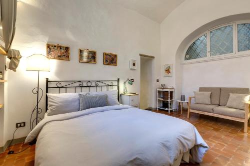 um quarto com uma cama, um sofá e uma janela em Florence Holiday Homes Ponte Vecchio em Florença