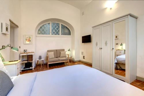 um quarto com uma cama, uma cadeira e uma janela em Florence Holiday Homes Ponte Vecchio em Florença