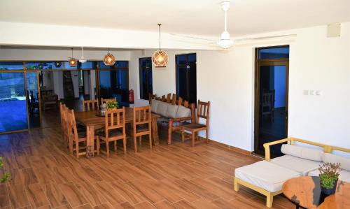 uma sala de estar com uma mesa e cadeiras e um sofá em Private Backdoor Villa with big swimming pool and services of chef included em Praia de Diani