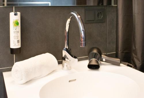 La salle de bains est pourvue d'un lavabo et d'un robinet. dans l'établissement ZWI Hotel by WMM Hotels, à Zwickau