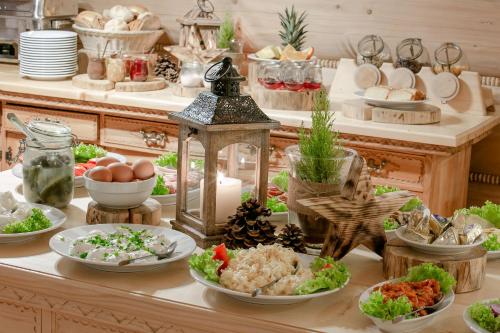 un buffet avec des assiettes de nourriture sur une table dans l'établissement Góralski Gościniec & SPA, à Poronin