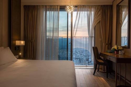 Cette chambre comprend un lit, un bureau et une fenêtre. dans l'établissement Panorama apartment Nha Trang, à Nha Trang