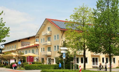 un gran edificio amarillo con gente caminando delante de él en Appartementhaus Stöckl, en Bad Füssing