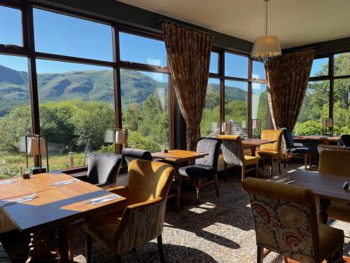 - un restaurant avec des tables, des chaises et de grandes fenêtres dans l'établissement The Mary Mount Hotel, à Keswick