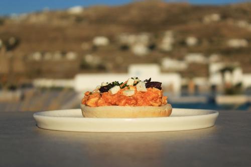 un sándwich en un plato blanco en una mesa en Adama Mykonos Boutique Hotel en Mykonos