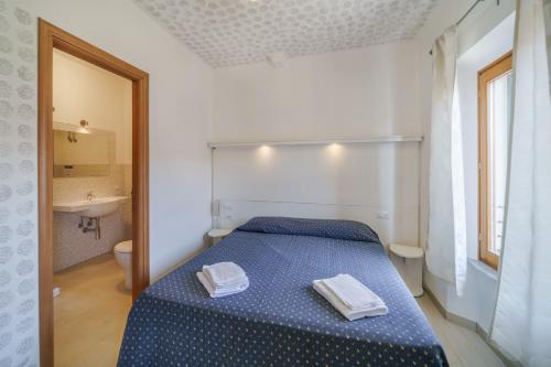 a bedroom with a blue bed with two towels on it at Affittacamere Vista Mare in Porto Azzurro