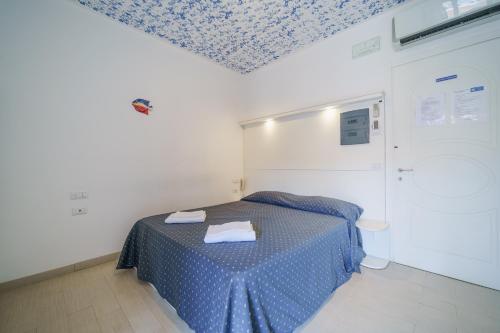 a room with a bed with a blue patterned ceiling at Affittacamere Vista Mare in Porto Azzurro