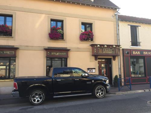 un camion noir garé devant un bâtiment dans l'établissement Le Celtic, à Le Thillay