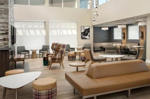 a waiting area with tables and chairs and tablesktop at Residence Inn by Marriott Lubbock-University Area in Lubbock