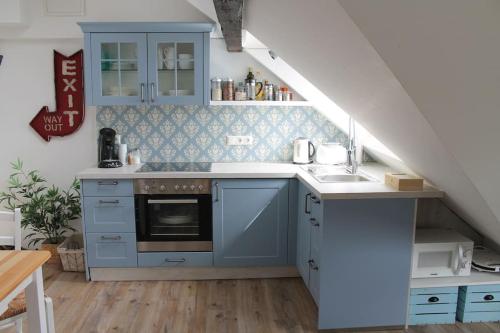 a kitchen with blue cabinets and a sink at Ferienwohnung Luna in Trier