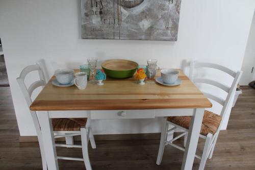 a wooden table with two chairs and a bowl on it at Ferienwohnung Luna in Trier