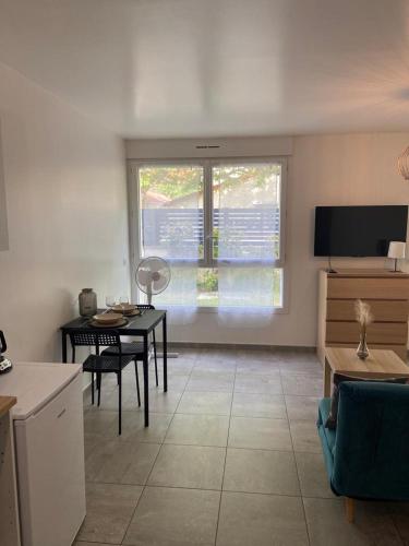 a living room with a table and a television at Grand Studio neuf in Aulnay-sous-Bois