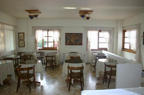 - une salle à manger avec des tables, des chaises et des fenêtres dans l'établissement Pramataris, à Monemvasia