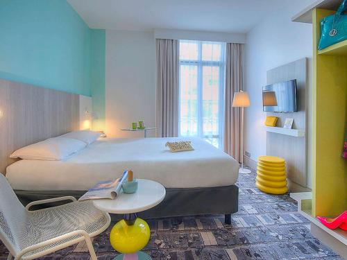 um quarto de hotel com uma cama, uma mesa e cadeiras em Ibis Styles Nice Centre Gare em Nice