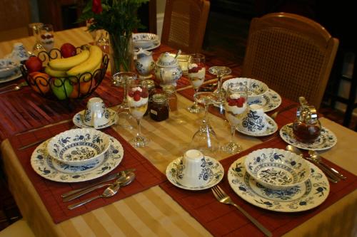 uma mesa com um conjunto de mesa com pratos e pratos em Gingerbread Manor em Montréal