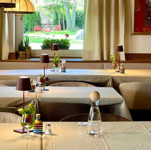 a restaurant with several tables with white tablecloths at Ameiserhof Guesthouse in Collalbo