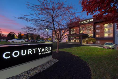 ein Schild vor einem Gebäude mit einem Autohändler in der Unterkunft Courtyard by Marriott Cincinnati Airport in Erlanger