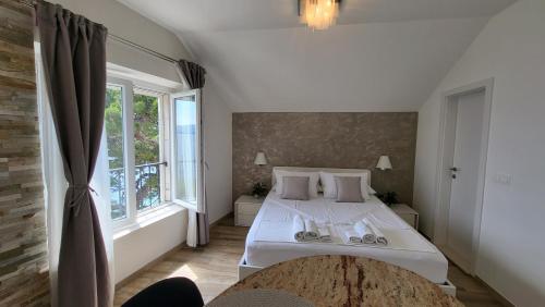 1 dormitorio con cama blanca y ventana grande en Old Town Sea Front M&M Apartment Korčula, en Korčula