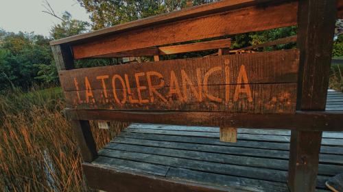 a sign on a wooden boardwalk with the words hidden and ak at La Tolerancia in Tigre