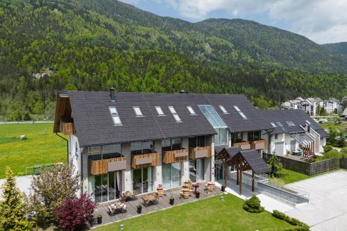 eine Luftansicht eines Hauses mit Bergen im Hintergrund in der Unterkunft Boutique Skipass Superior Hotel in Kranjska Gora