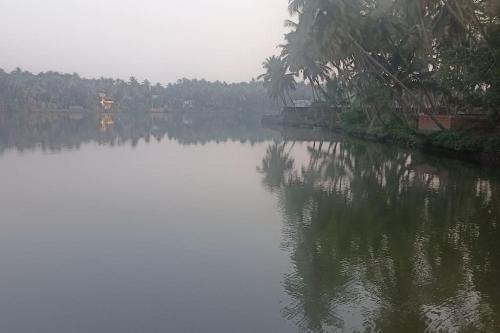 une grande masse d'eau avec des arbres à l'arrière-plan dans l'établissement Ocean Pearl, à Kozhikode