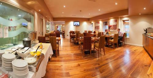 a restaurant with tables and chairs and people sitting at them at Imperial Hotel Galway in Galway