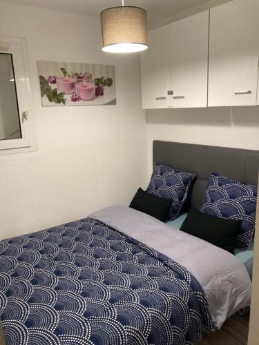 una camera da letto con letto con lenzuola e cuscini blu di Appartement vacances cap d’agde a Cap d'Agde