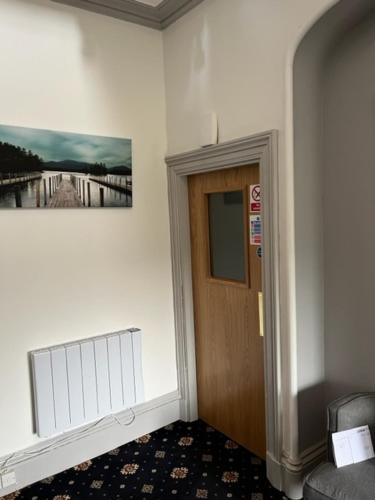 un pasillo con una puerta y una foto en la pared en Duchally House, en Nairn