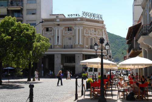 a street with tables and umbrellas in front of a building at Hotel Colonial Salta in Salta