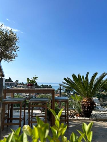 um pátio com mesas e cadeiras com o oceano ao fundo em Hotel Senator em Ulcinj