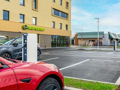 a car parked in a parking lot in front of a building at B&B HOTEL Sélestat Centre-Alsace in Sélestat