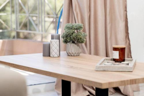 d'une table en bois avec un vase recouvert d'une plante. dans l'établissement Omnia Maisonette by A&D Properties, à Pórto Ráfti