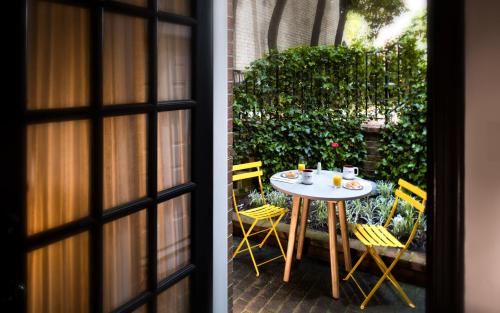 een tafel en stoelen voor een patio bij The Poppy Georgetown Guesthouse and Gardens in Washington