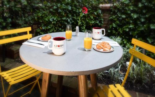 een tafel met een ontbijt van jus d'orange en croissants bij The Poppy Georgetown Guesthouse and Gardens in Washington