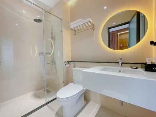 a bathroom with a toilet and a sink and a mirror at Sunflower Hotel & Resort in Bao Loc