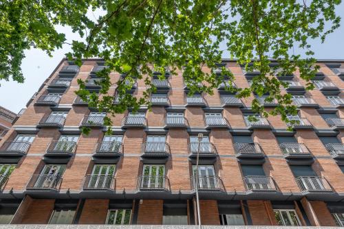 um edifício de tijolos alto com muitas janelas em Numa I Verso Apartments em Roma