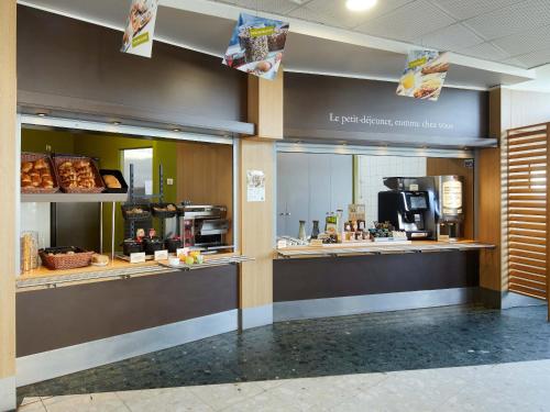 a lobby with a bakery with aasteryasteryasteryasteryasteryasteryasteryasteryastery at B&B HOTEL Paris Roissy CDG Aéroport in Roissy-en-France