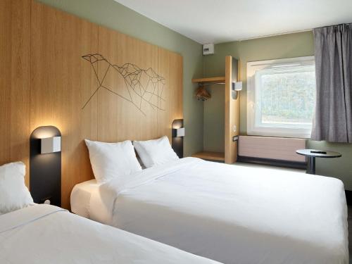 a hotel room with two beds and a window at B&B HOTEL Paris Roissy CDG Aéroport in Roissy-en-France