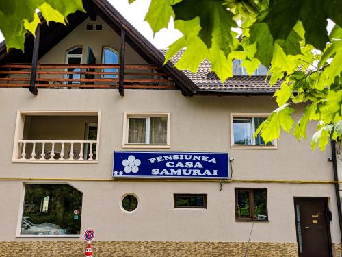 een gebouw met een bord voor een autosalon bij Pension Casa Samurai in Braşov