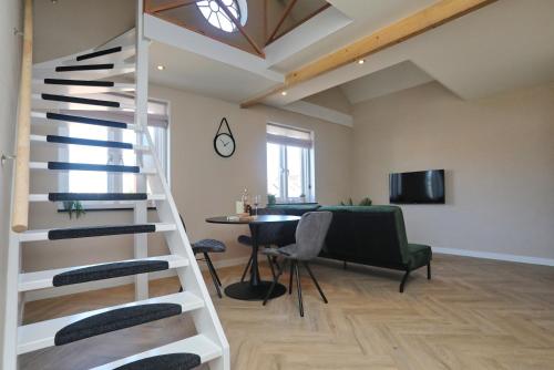 - un escalier en colimaçon dans un salon avec une table dans l'établissement appartement-gratis parkeren -bij strand en in het centrum, à Noordwijk