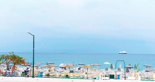 plaża z leżakami i parasolami oraz ocean w obiekcie SeaSTAR Beach Apartments w mieście Kos